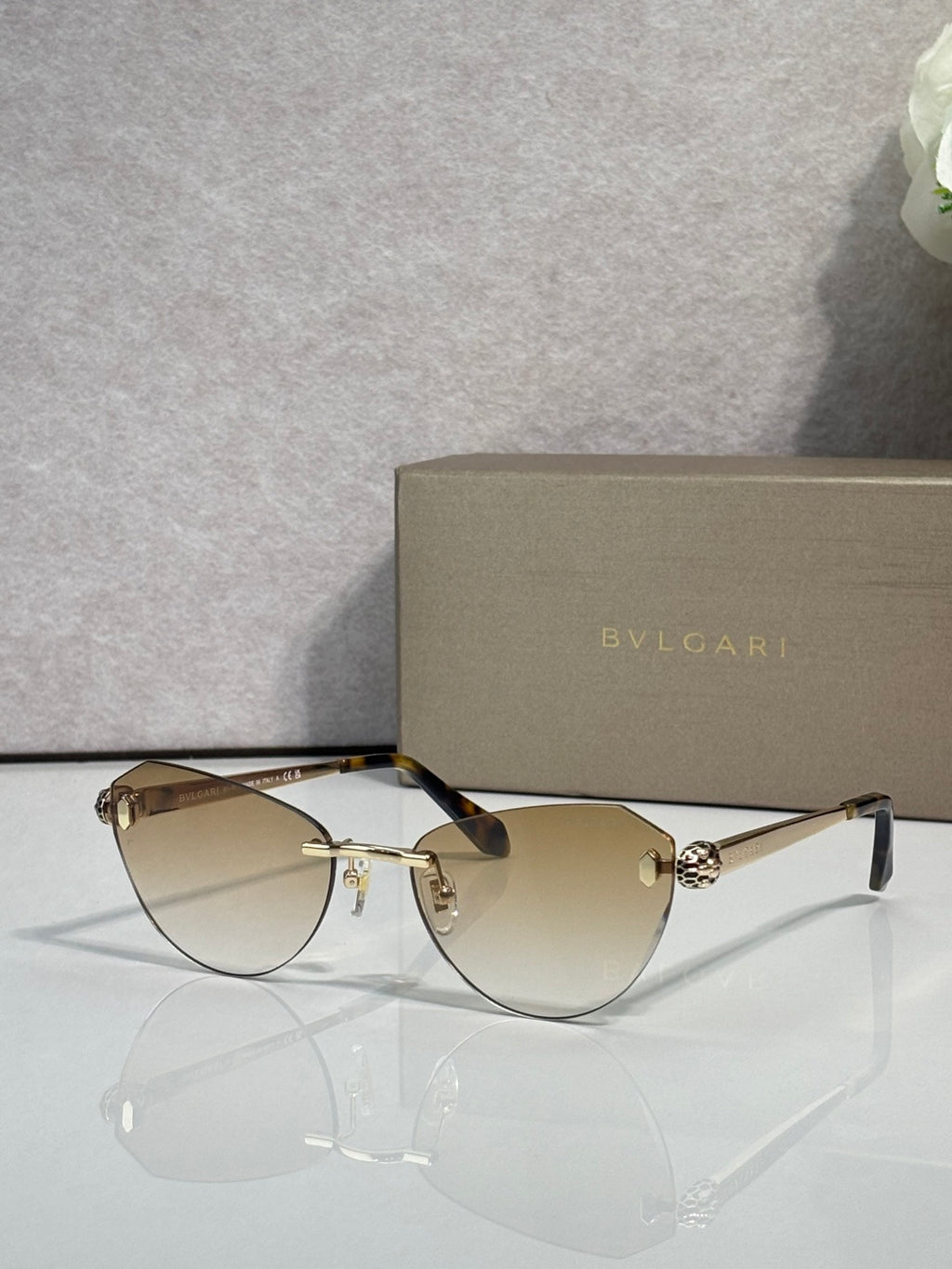 Sunglasses with amber tinted lenses, black frame, and gold metal accents