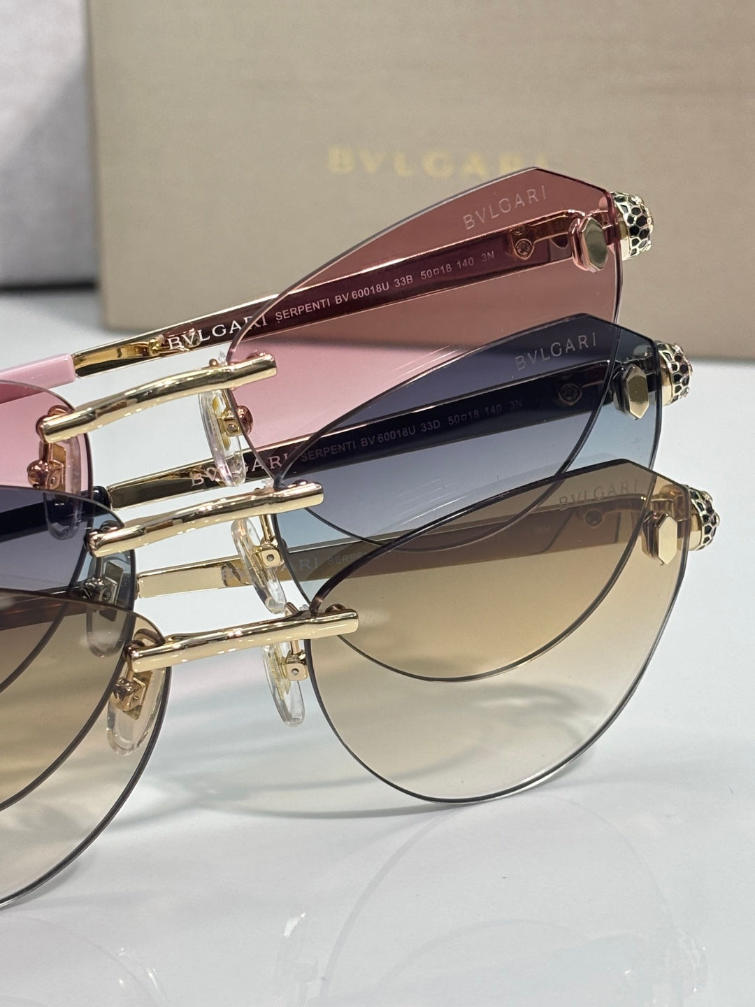 Sunglasses close-up: pink and amber lenses with gold frames and double temples