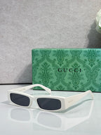 Gucci sunglasses with white frames and dark tinted lenses