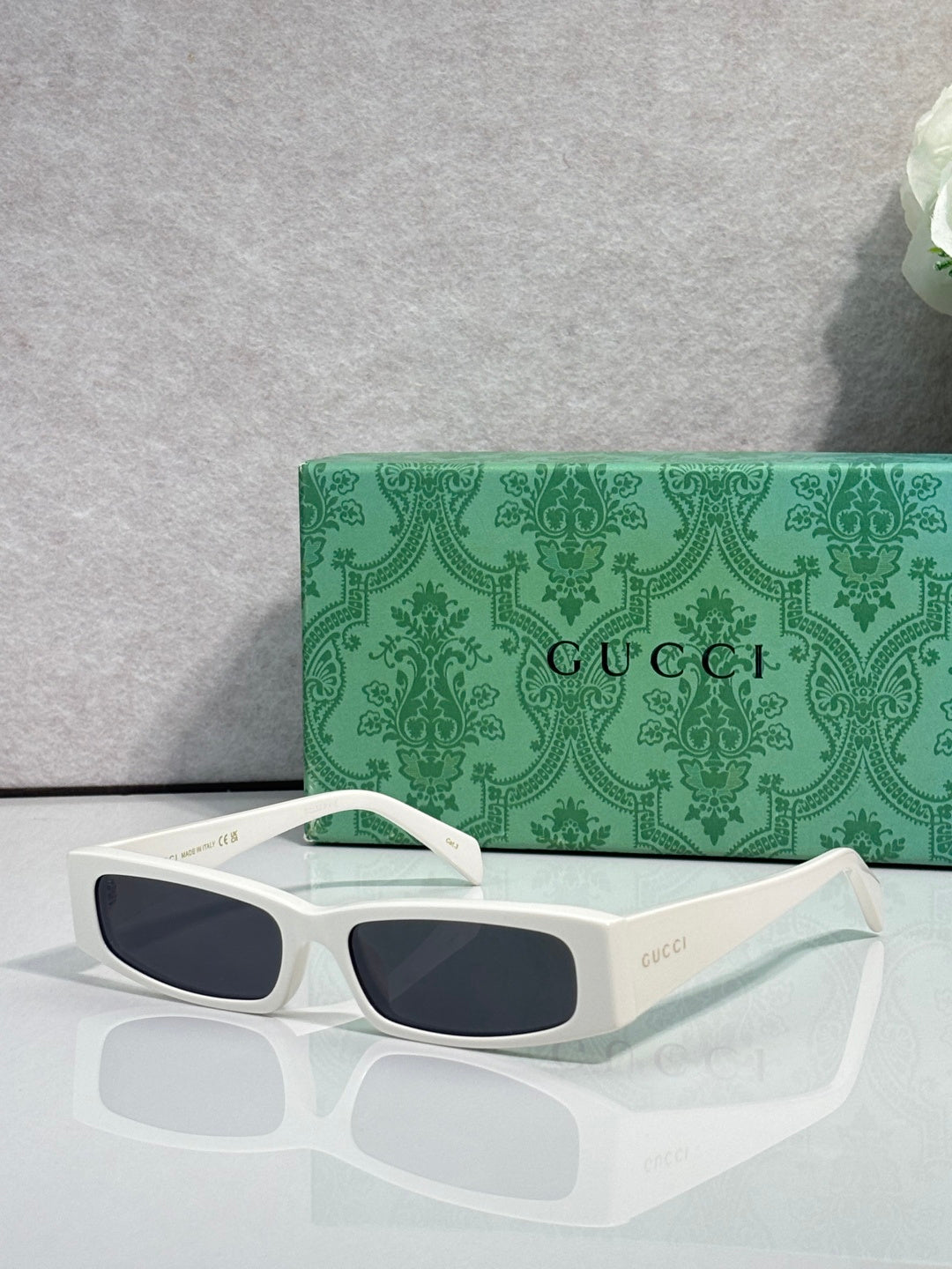 Gucci sunglasses with white frames and dark tinted lenses