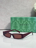 Gucci sunglasses with dark maroon frames and brown tinted lenses