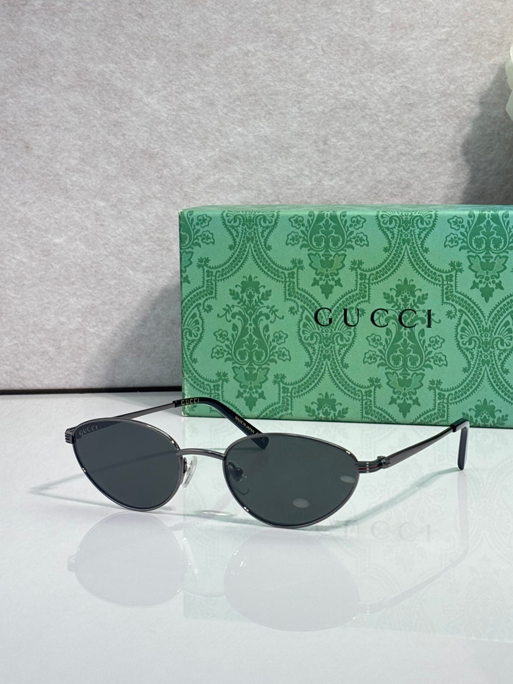 Gucci sunglasses with black frame and dark oval lenses