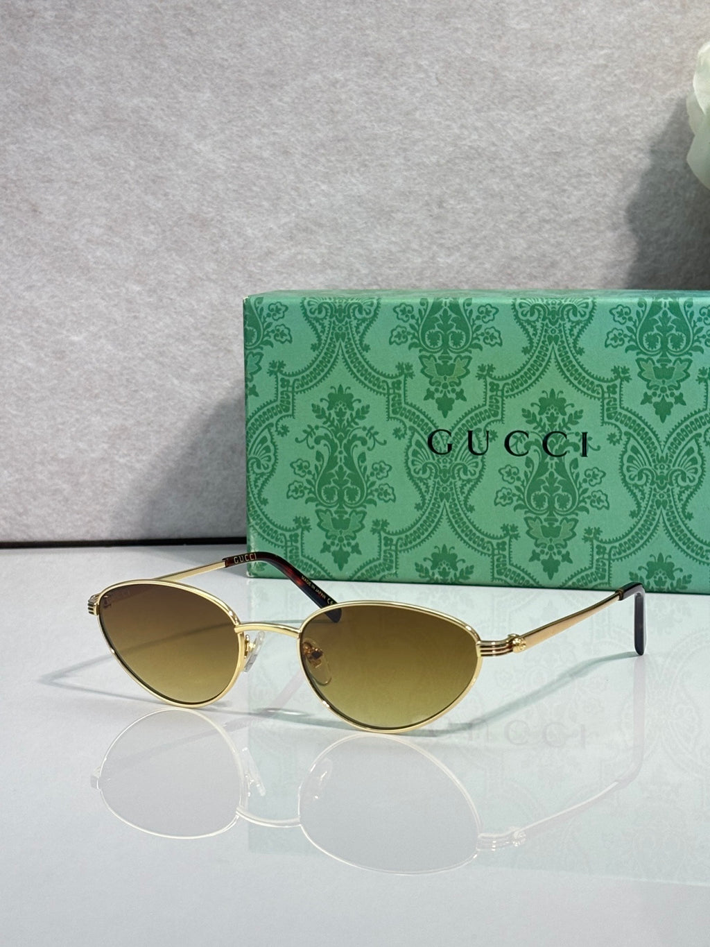 Gucci sunglasses with gold-tone frame and amber tinted lenses
