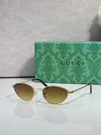 Gucci sunglasses with gold-tone frame and amber tinted lenses