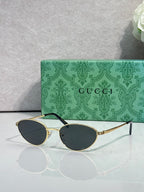 Gucci sunglasses with gold-tone frame and dark oval lenses