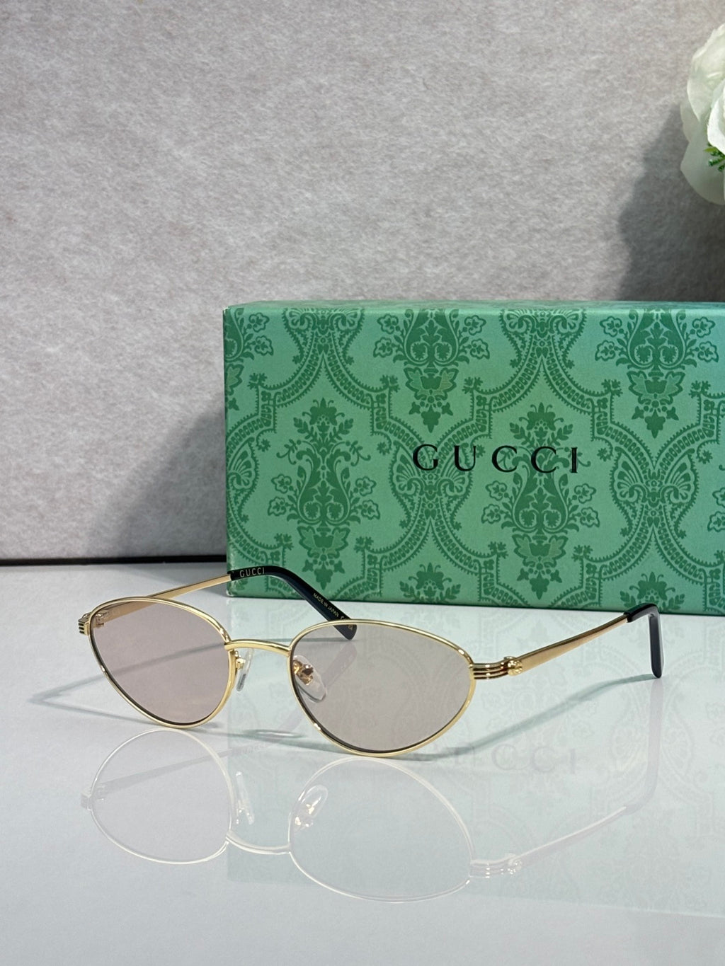 Gucci sunglasses with gold-tone frame and clear lenses