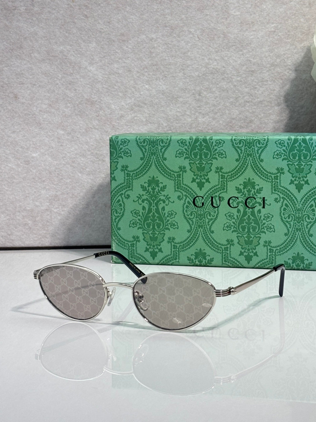 Gucci sunglasses with silver-tone frame and light gray patterned lenses