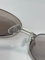 Gucci sunglasses close-up: silver bridge and temple with logo detail