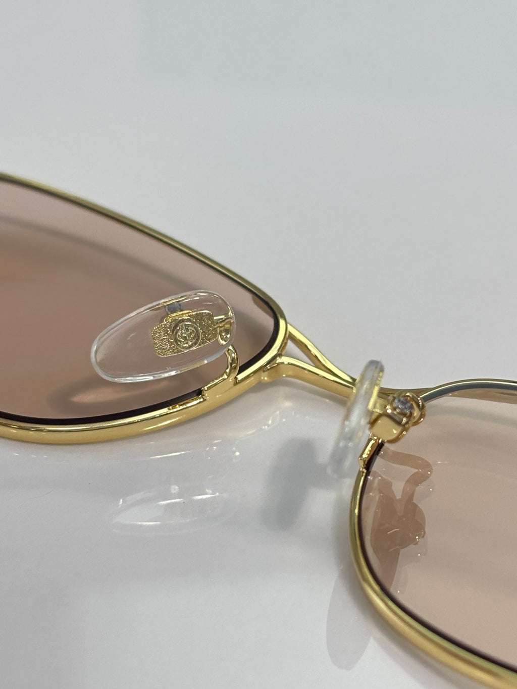Gucci gold-tone sunglasses frame close-up with decorative temple detail
