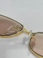 Gucci gold-tone sunglasses frame close-up with decorative temple detail