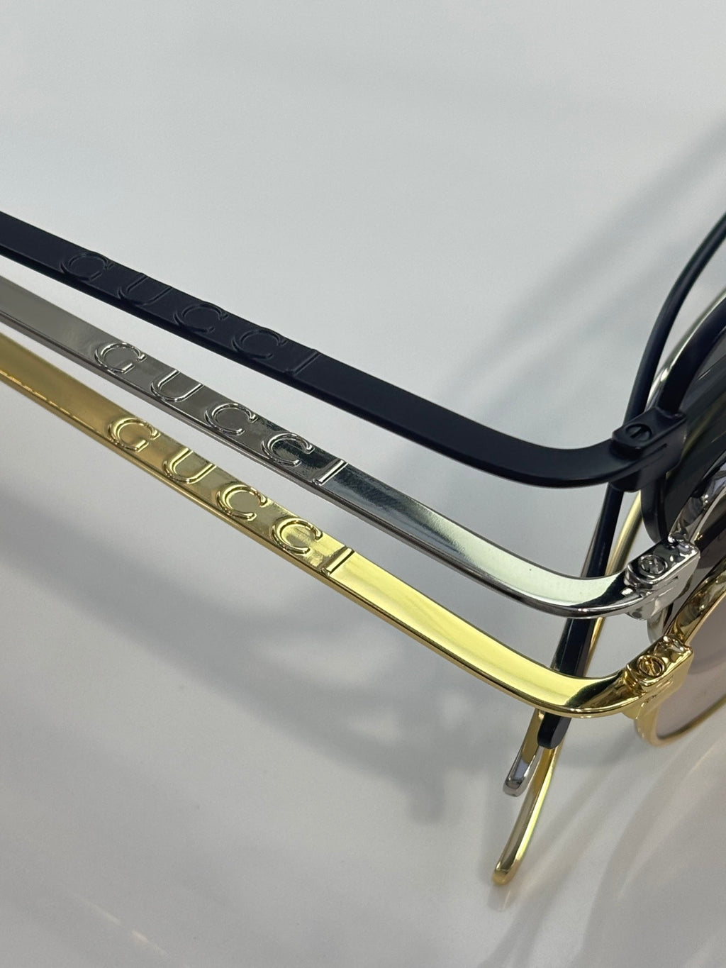 Gucci sunglasses close-up of hinge and metal temple with engraved detailing