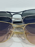 Gucci sunglasses close-up with gold and silver frames and dark blue tinted lenses