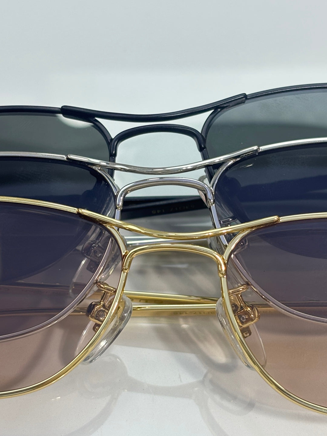 Gucci sunglasses close-up with gold and silver frames and dark blue tinted lenses