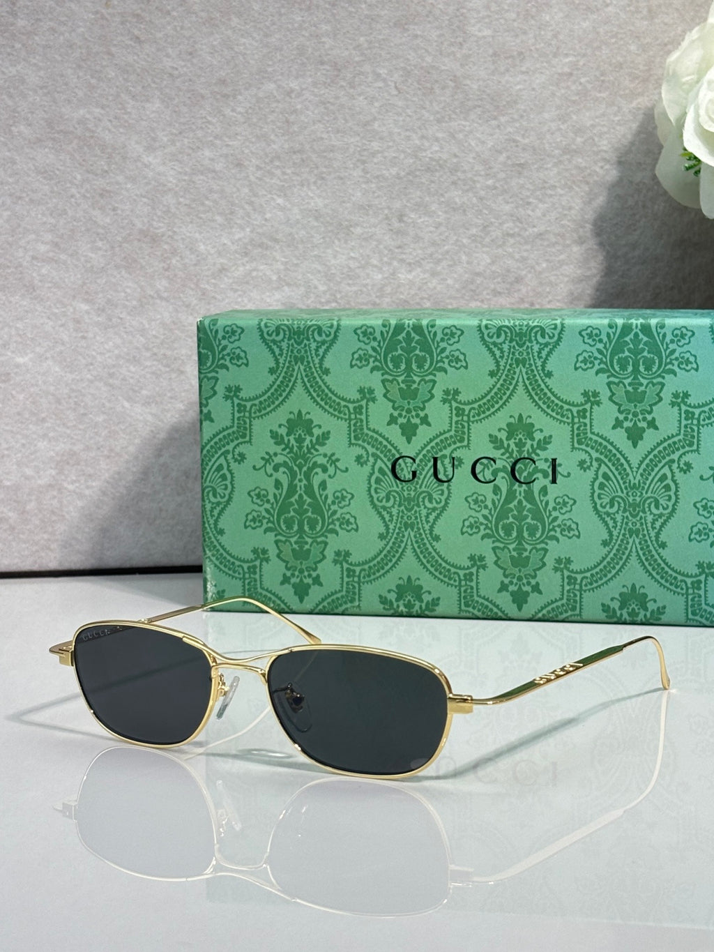 Gucci sunglasses with gold frame and dark lenses, oval shape