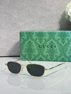 Gucci sunglasses with gold frame and dark lenses, oval shape