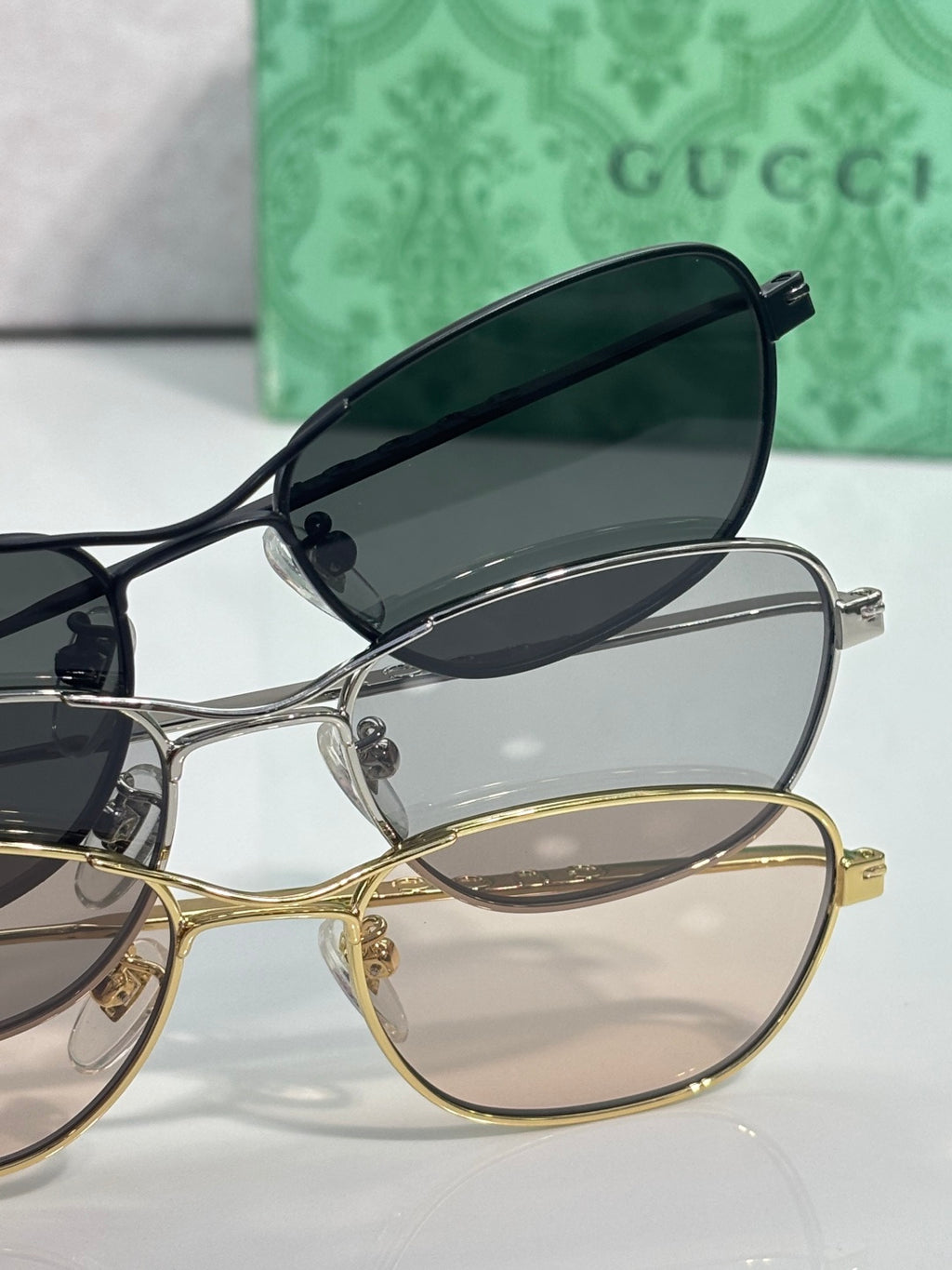 Gucci sunglasses stack view with black frame and gold frame, oval lenses