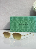 Gucci sunglasses with gold frame and olive tinted lenses, oval shape