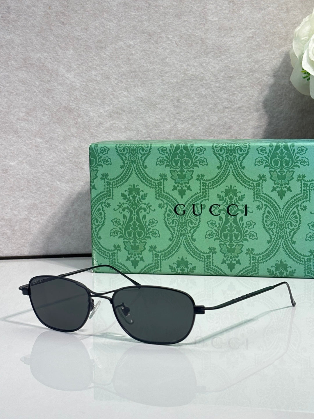 Gucci sunglasses with black frame and dark tinted lenses, oval shape