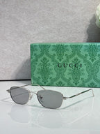 Gucci sunglasses with silver frame and gray tinted lenses, oval shape