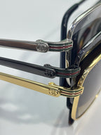 Gucci sunglasses close-up: chrome hinge details with gold arm and black temples
