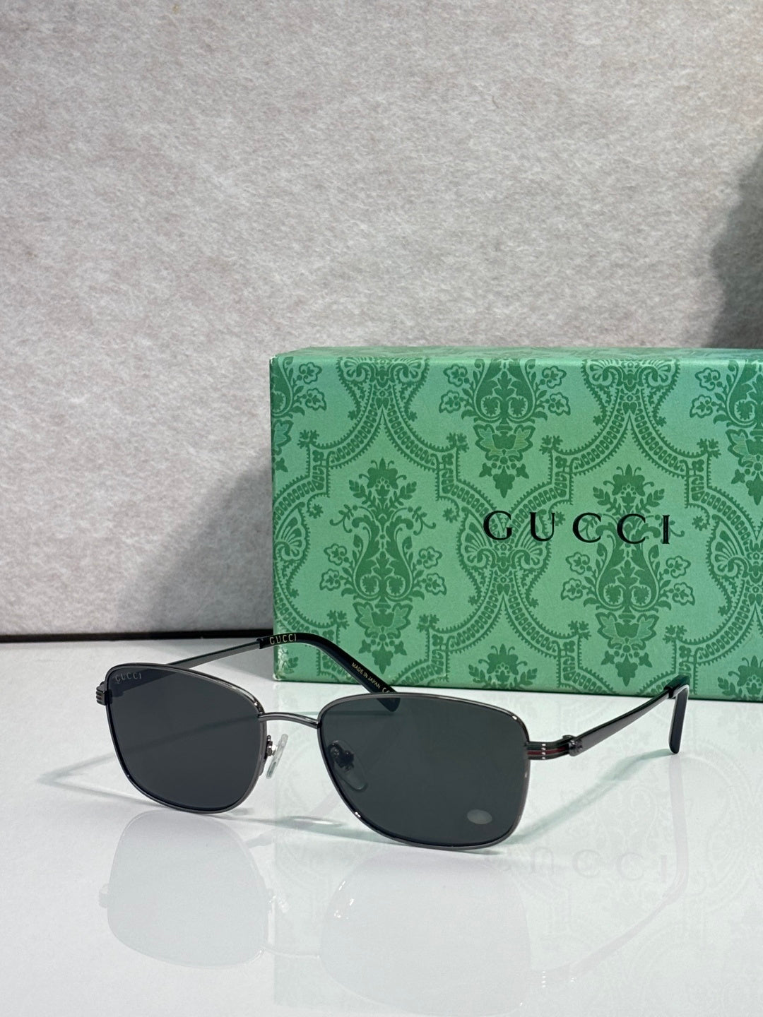 Gucci sunglasses with dark lenses, gold frame, side-on front view