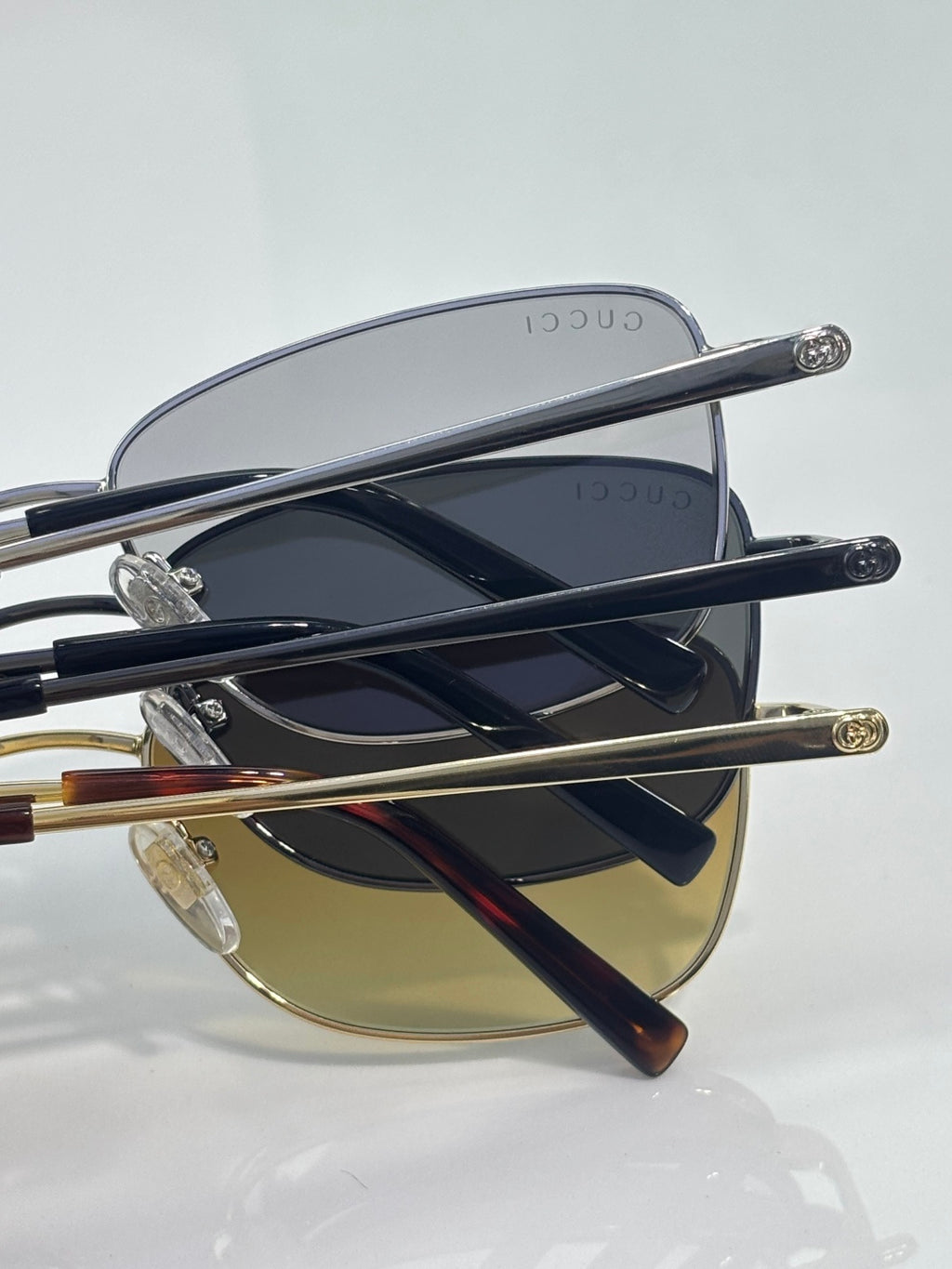 Sunglasses side view: silver frame with dark lens and gold accent temple tips