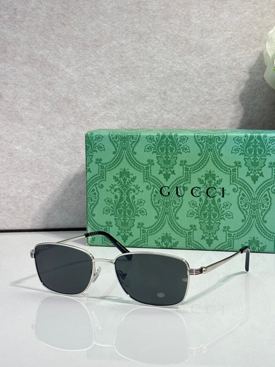 Sunglasses with dark lenses and silver-toned frame with black temple tips