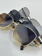 Sunglasses close-up with navy and gold frames, oval lenses and metal temples