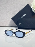 Chanel glasses with dark blue oval frames, light blue lenses, and gold logo temples.