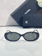 Chanel sunglasses with dark blue round-oval frames and gold temple logo