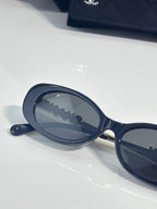 Chanel sunglasses with oval lens and dark blue frame, side close-up