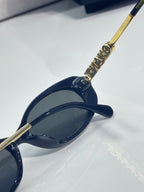 Chanel sunglasses, angled side view with gold embellished hinge and dark blue lens