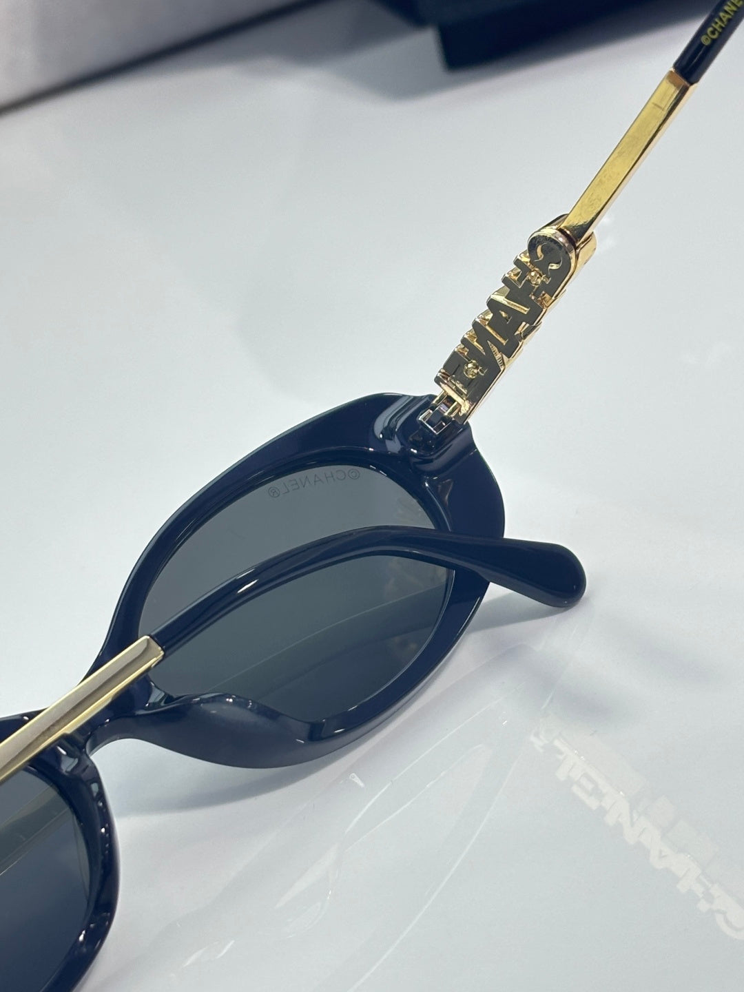 Chanel sunglasses, angled side view with gold embellished hinge and dark blue lens