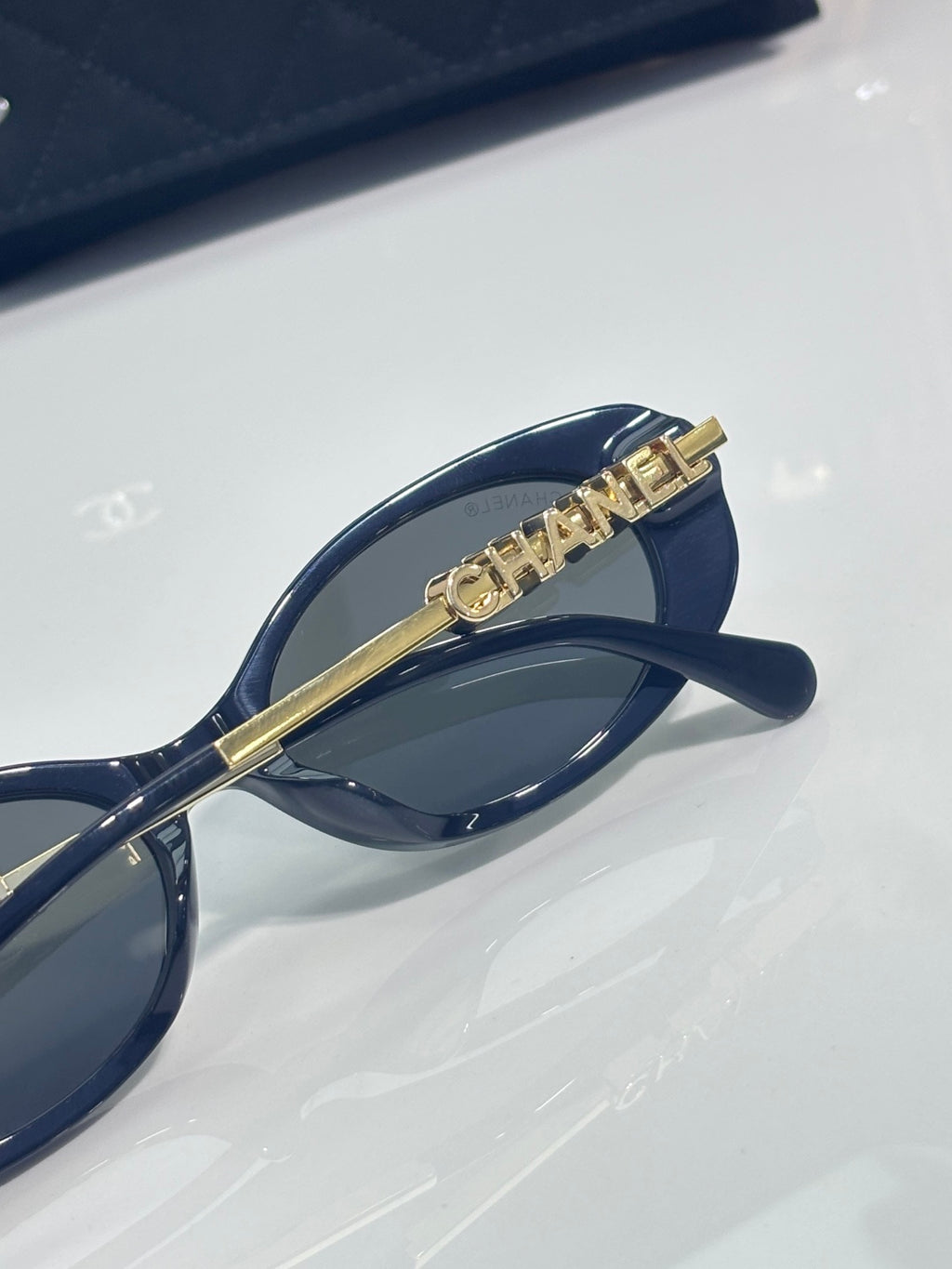Chanel sunglasses with gold bar bridge detail and dark blue frame