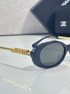 Chanel sunglasses, side view with gold patterned temple and dark blue frame