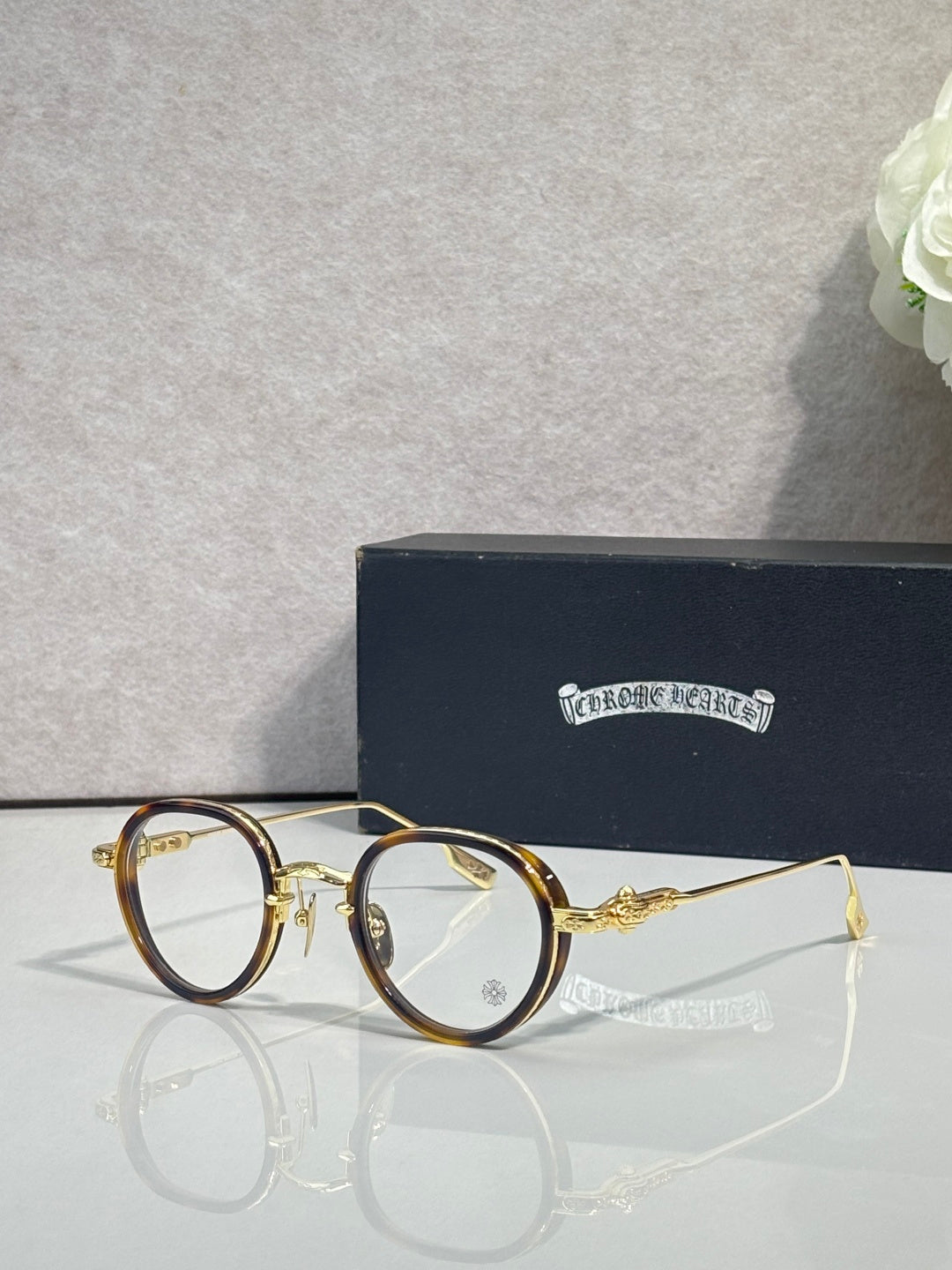 Chrome-finish round eyeglasses with gold frames and clear lenses