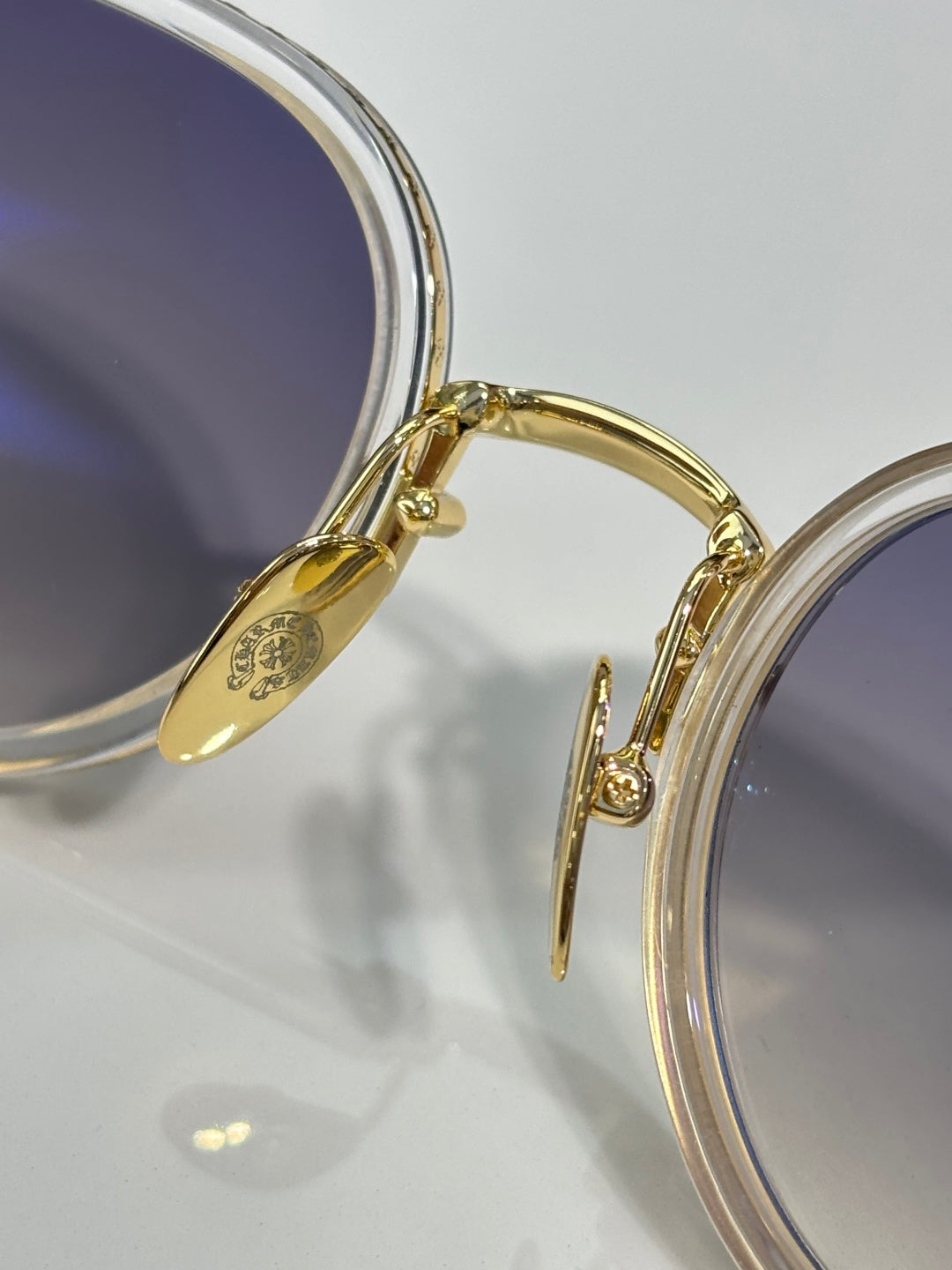Chrome glasses close-up: gold frame bridge and temple with lens rim