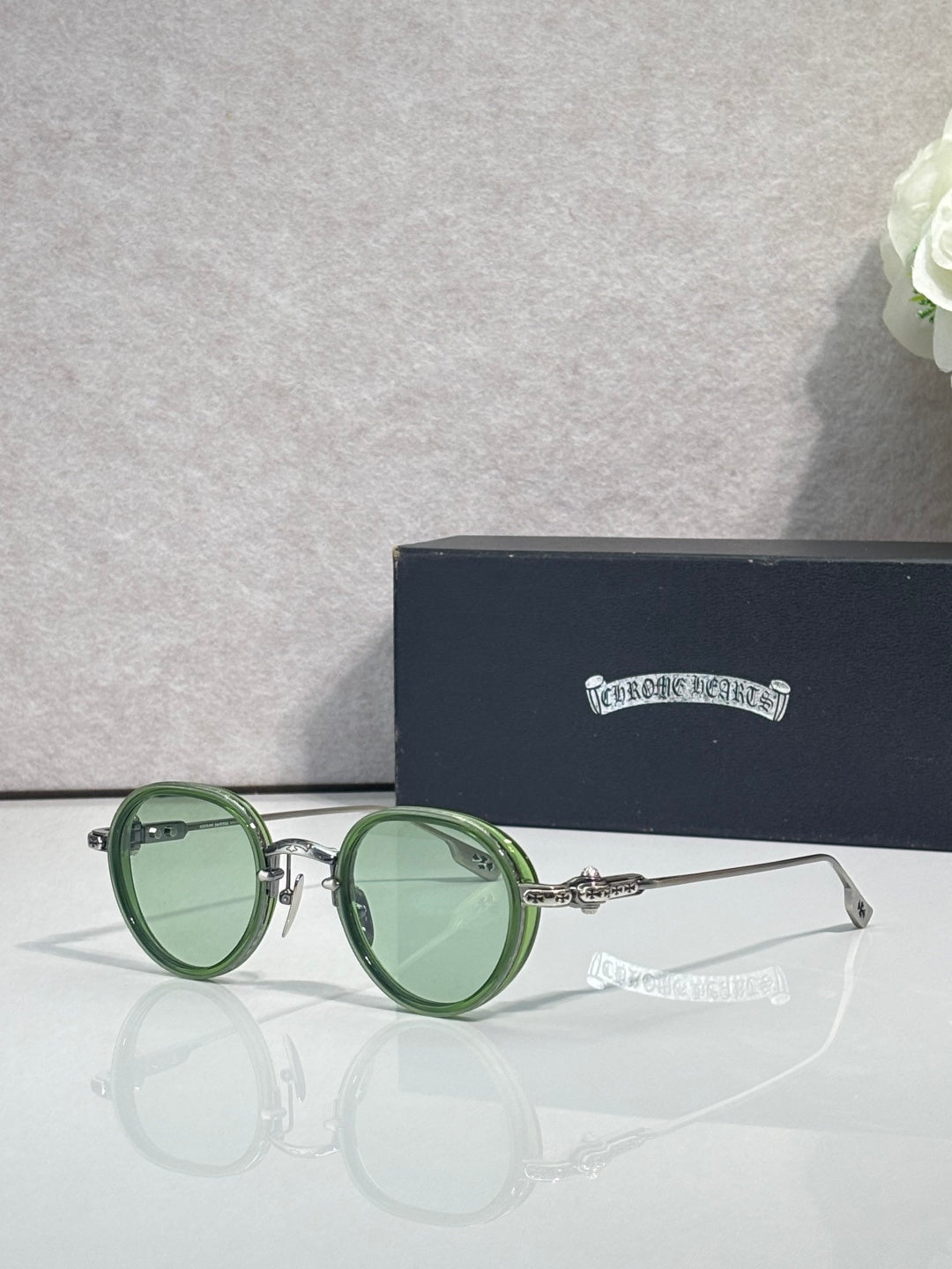 Chrome round glasses with green lenses and green frame, metal hinge details