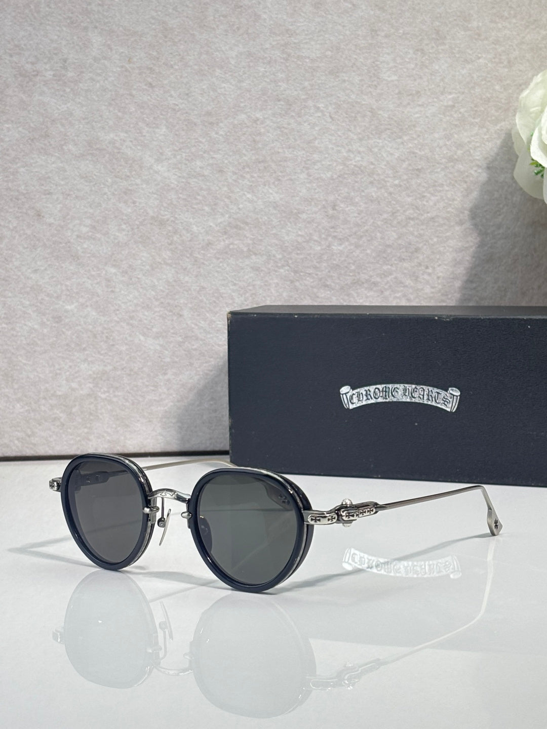 Chrome round glasses with dark tinted lenses and dark frames, slim metal arms