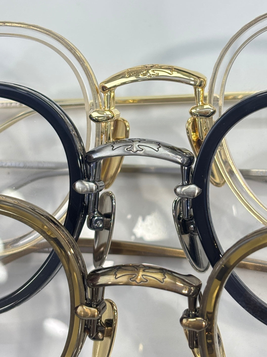 Chrome-finish eyeglasses close-up showing gold and dark frames with clear lenses