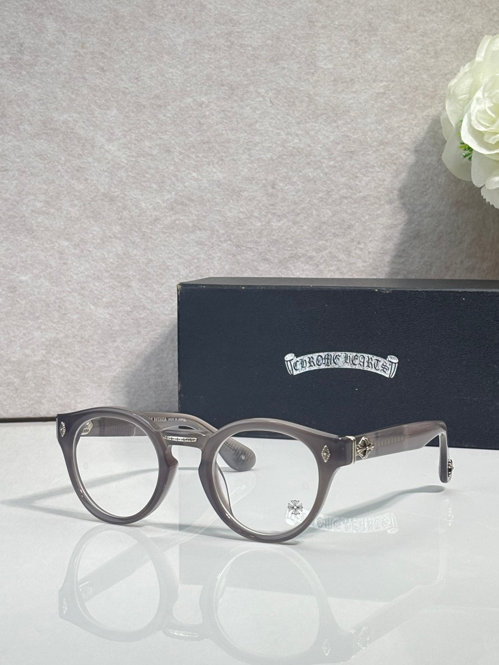 Gray round eyeglasses with gold-tone detailing and clear lenses