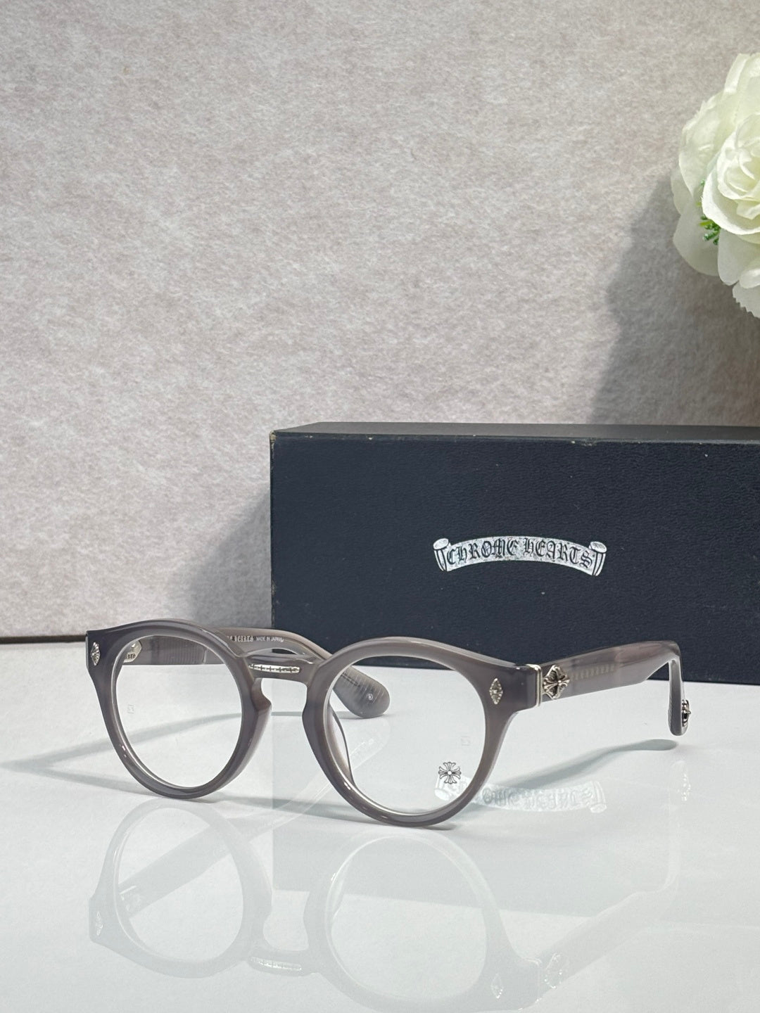 Gray round eyeglasses with gold-tone detailing and clear lenses