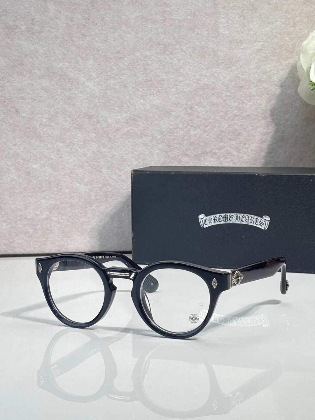 Black round eyeglasses with gold-tone detailing and clear lenses