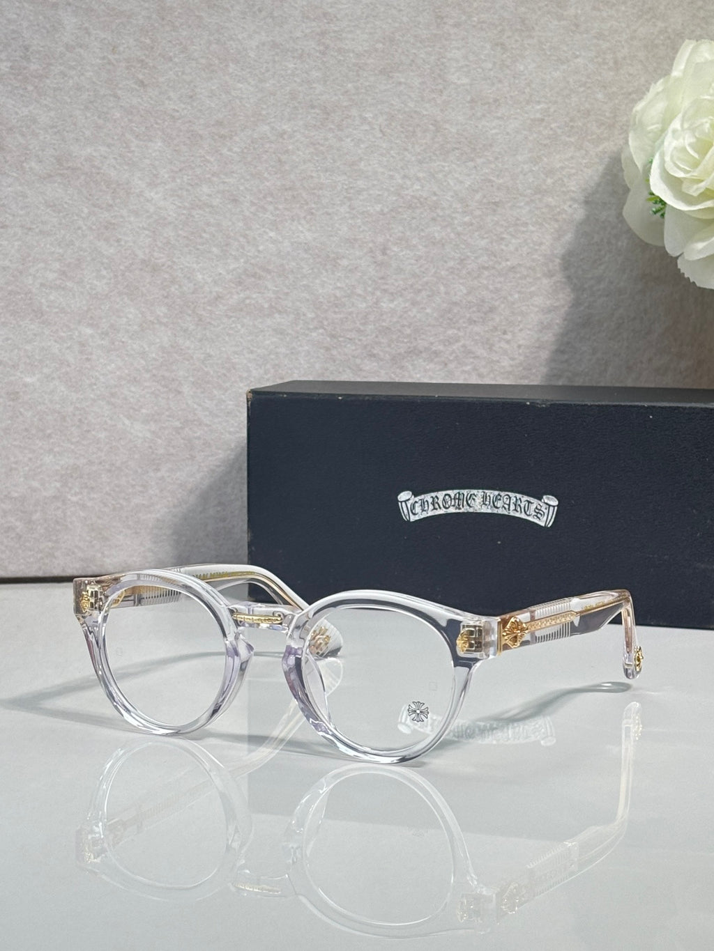 Silver round eyeglasses with gold-tone hinges and clear lenses