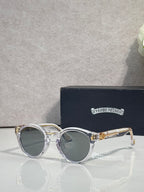Silver round sunglasses with gray tinted lenses and decorative side detailing