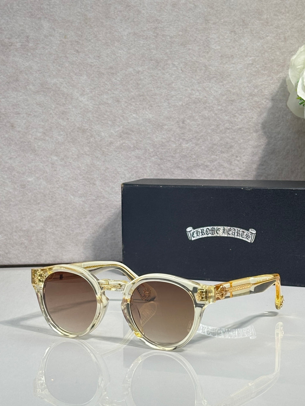 Gold round sunglasses with brown tinted lenses and clear front detail