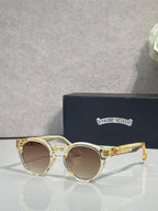Gold round sunglasses with brown tinted lenses and clear front detail