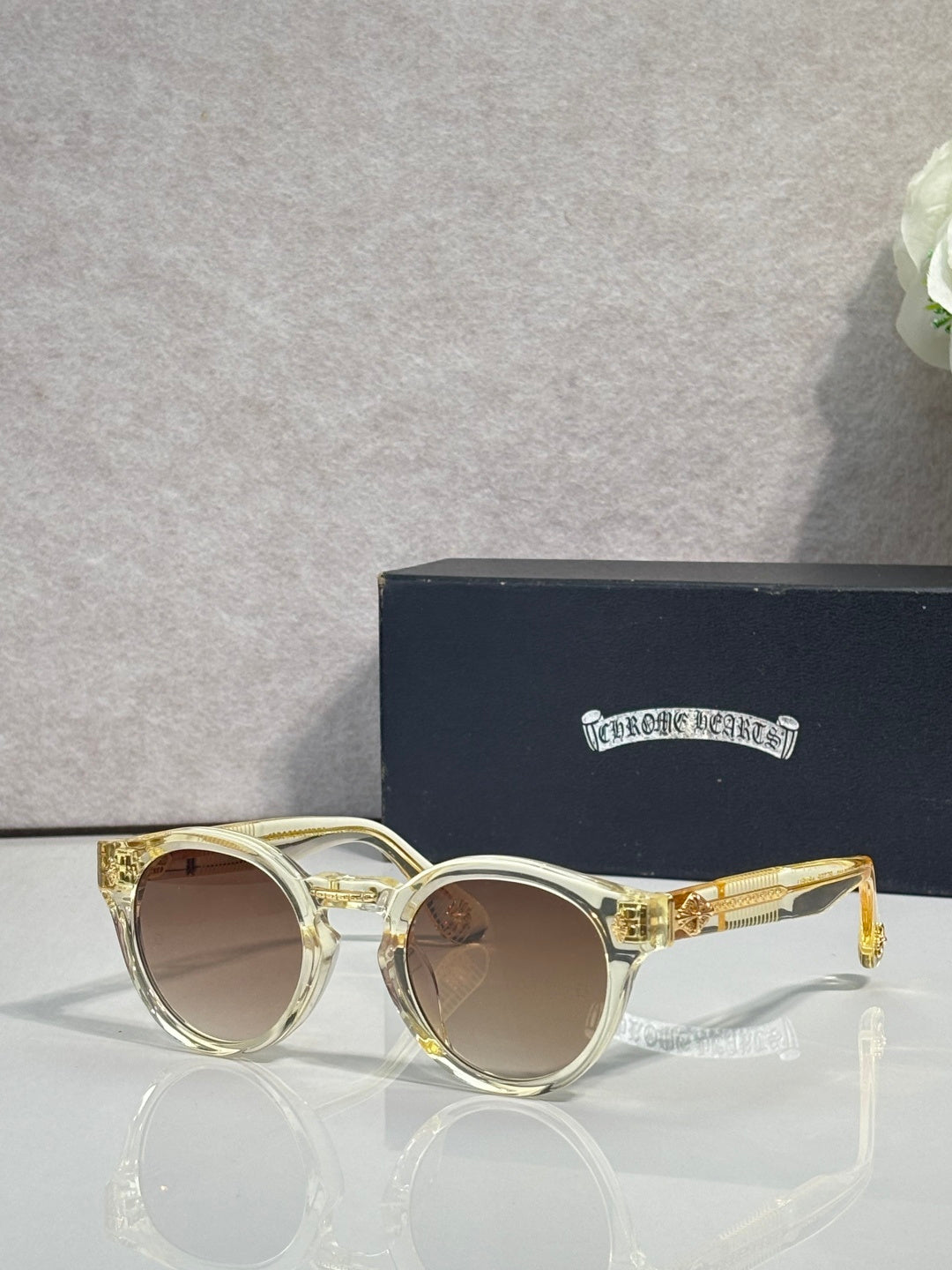Gold round sunglasses with brown tinted lenses and clear front detail