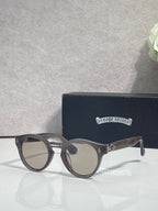 Gray round sunglasses with dark gray tinted lenses and metal temple accents