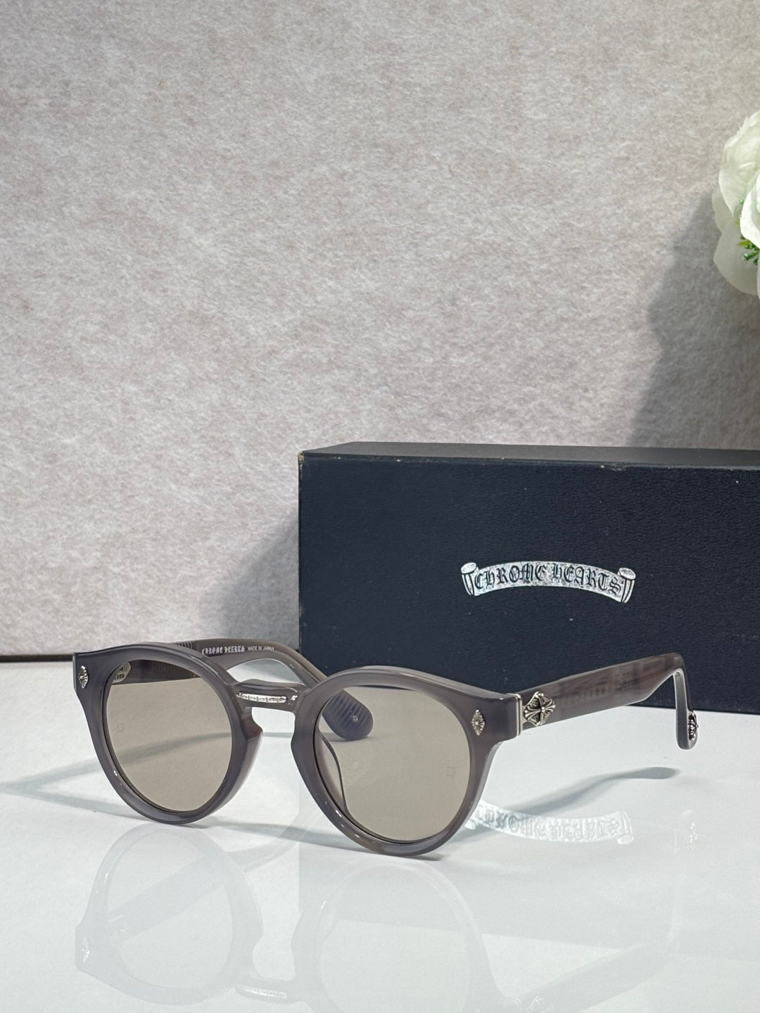 Gray round sunglasses with dark gray tinted lenses and metal temple accents